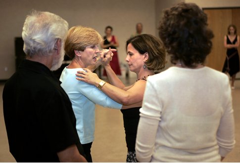 Dance instructor Sue Flanagan (second from left) shows student Barbara Valdez some tango moves as fellow class members look on.